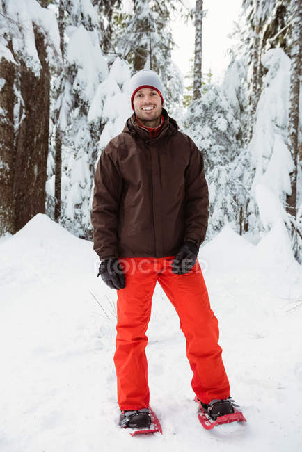 Portrait of smiling skier standing on snow covered landscape — Stock Photo