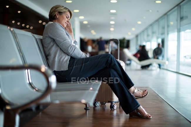 Empresária dormindo na cadeira na área de espera no terminal do aeroporto — Fotografia de Stock