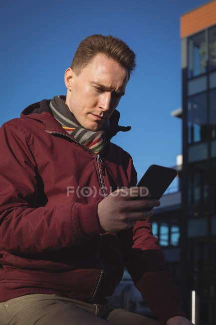 Чоловік-виконавчий виступ на мобільному телефоні на вулиці перед офісною будівлею — стокове фото