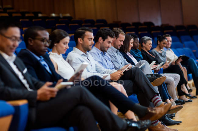 Бізнес-керівники, які беруть участь у діловій зустрічі за допомогою цифрового планшета в конференц-центрі — стокове фото