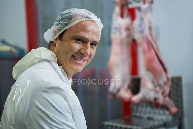 Portrait of smiling butcher at meat factory — Stock Photo