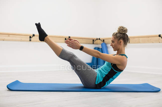Жінка, виконуючи вправи в фітнес-студії — стокове фото