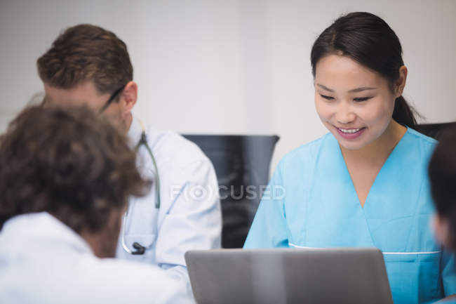 Enfermeira usando laptop na sala de conferências do hospital — Fotografia de Stock