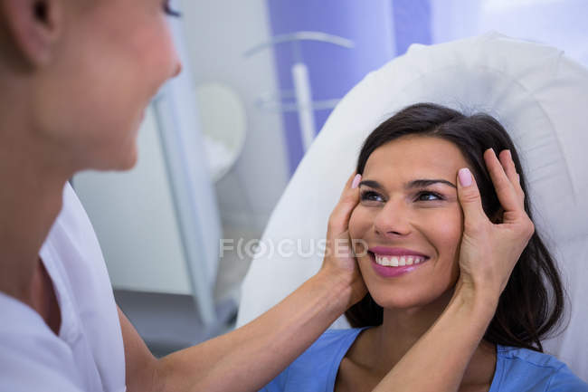 Médico examinando paciente femenina para tratamiento cosmético en la clínica - foto de stock