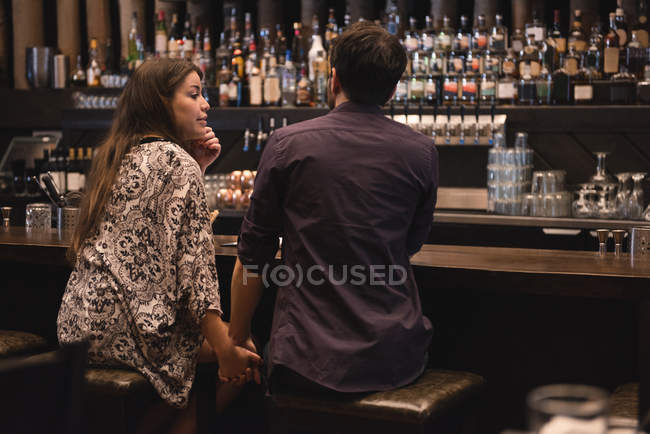 Пара сидить за барною стійкою і тримає руки — стокове фото