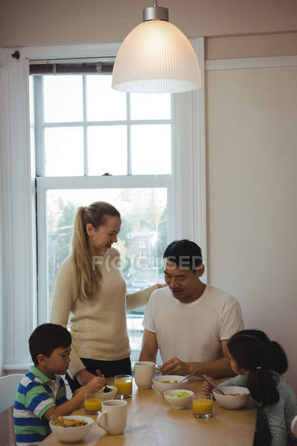 Счастливая семья, ужинающая дома за обеденным столом — стоковое фото
