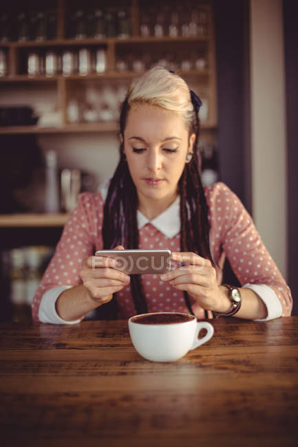 Woman using mobile phone in cafe — Stock Photo