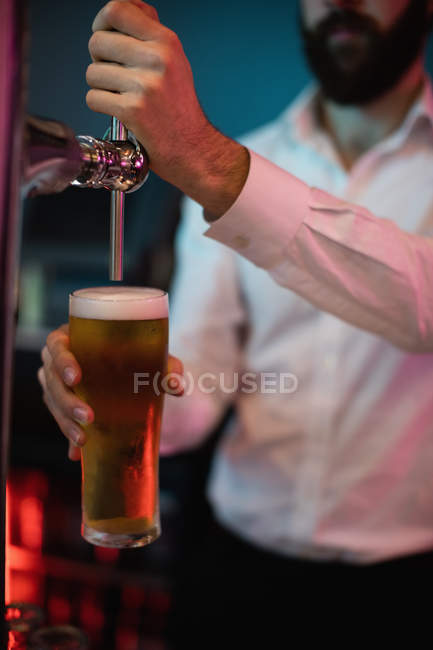Nahaufnahme vom Barkeeper, der Bier an der Theke aus der Zapfsäule füllt — Stockfoto