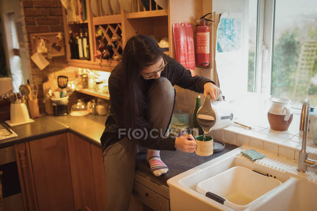 Mulher preparando café na cozinha em casa — Fotografia de Stock