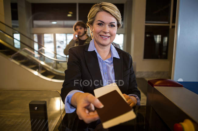 Donna d'affari consegna la carta d'imbarco al banco del terminal dell'aeroporto — Foto stock