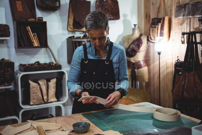 Craftswoman working on a piece of leather in workshop — Stock Photo