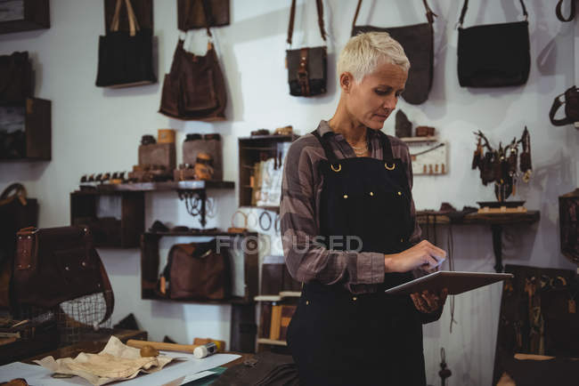 Ältere Handwerkerin nutzt digitales Tablet in Werkstatt — Stockfoto