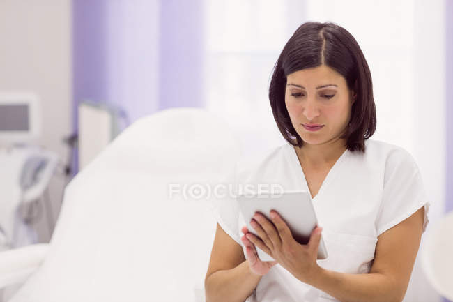 Dermatologista usando tablet digital na clínica — Fotografia de Stock