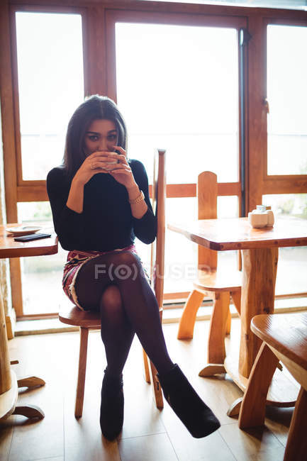 Portrait of beautiful woman having a cup of coffee in cafe — Stock Photo