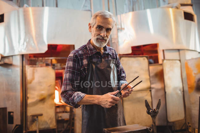 Ritratto di soffiatore che tiene le pinze nella fabbrica di soffiaggio del vetro — Foto stock