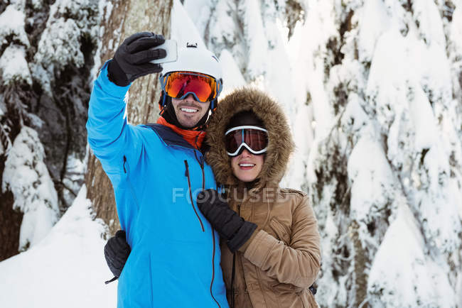 Щаслива пара лижників приймає селфі на засніженому ландшафті — стокове фото
