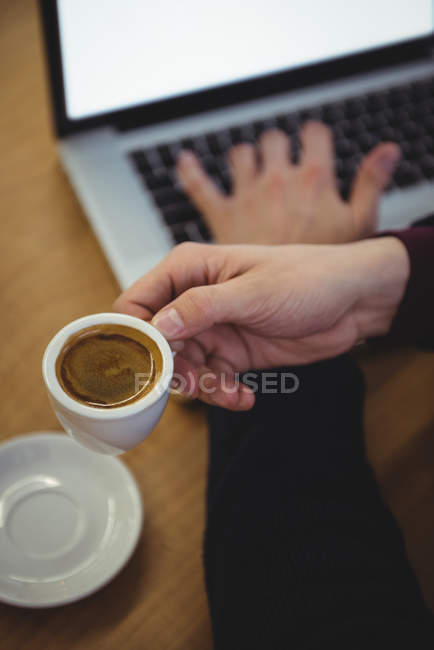 Man holding cup of coffee in coffee shop — Stock Photo