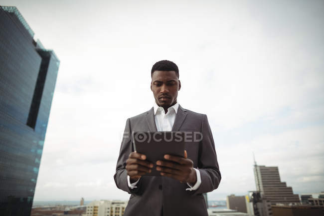 Бизнесмен с помощью цифрового планшета на офисной террасе — стоковое фото