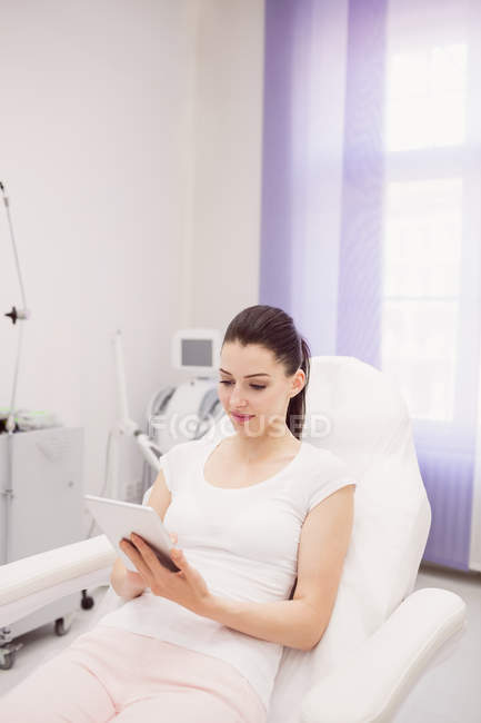 Mulher bonita usando tablet digital na clínica — Fotografia de Stock
