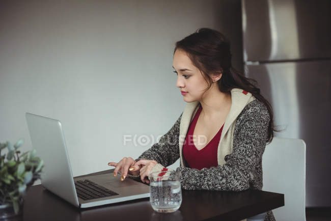 Woman working on laptop at home — Stock Photo