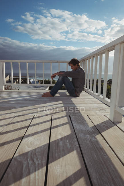 Вид сбоку на беспокойного мужчину, сидящего на балконе — стоковое фото