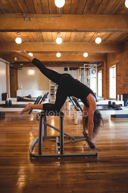 Mulher determinada praticando pilates em equipamentos de estúdio de fitness — Fotografia de Stock