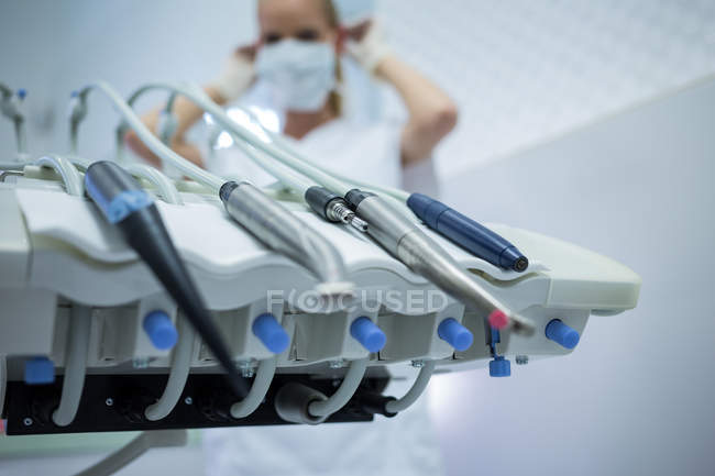 Gros plan des outils dentaires sur la machine de la clinique et le médecin en arrière-plan — Photo de stock