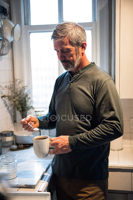 Homem preparando um café preto na cozinha em casa — Fotografia de Stock