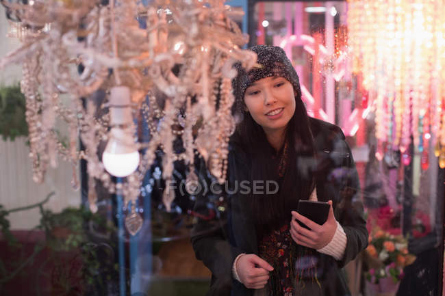 Woman looking at chandeliers in vintage store — Stock Photo