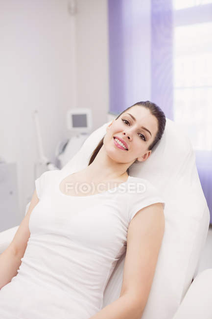 Retrato de una hermosa mujer sentada en la clínica - foto de stock
