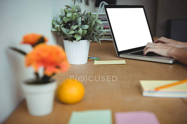 Hand of business executive using laptop in office — Stock Photo