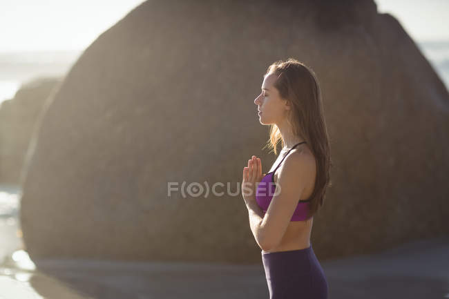 Schöne Frau meditiert an einem sonnigen Tag am Strand — Stockfoto