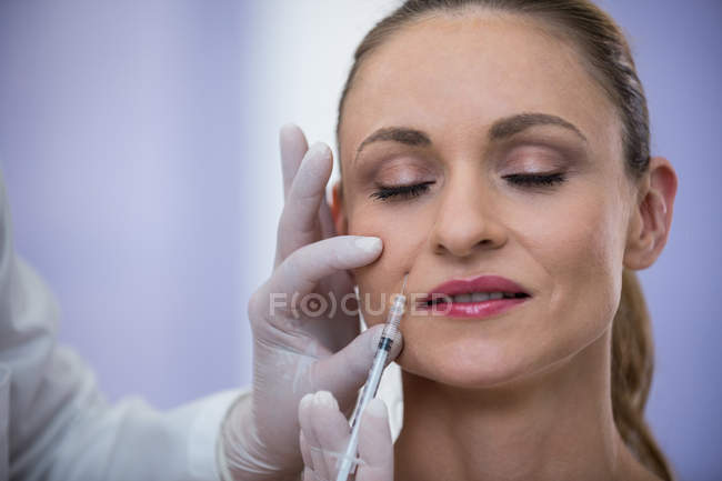 Mujer que recibe la inyección de botox en la clínica - foto de stock