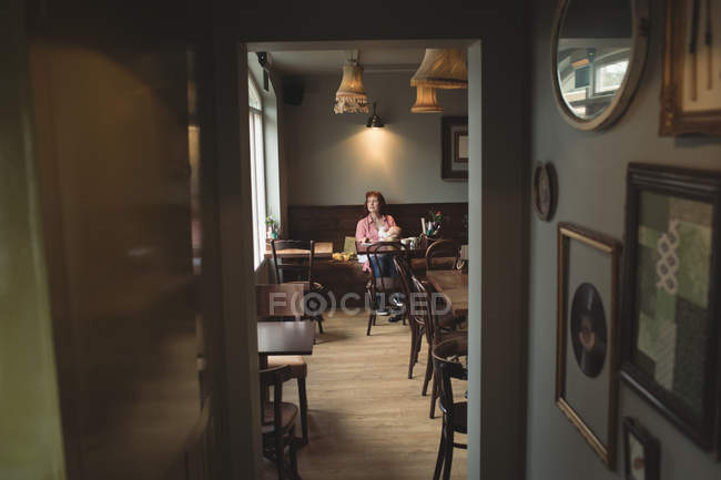 Mother breastfeeding baby in cafe interior — Stock Photo