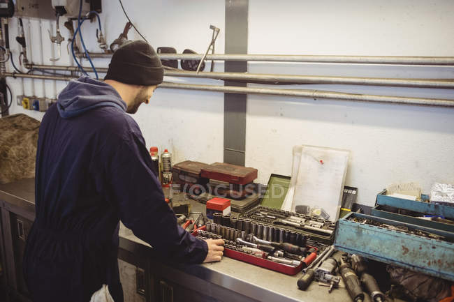 Mecánica de comprobación de varias herramientas en el garaje de reparación - foto de stock
