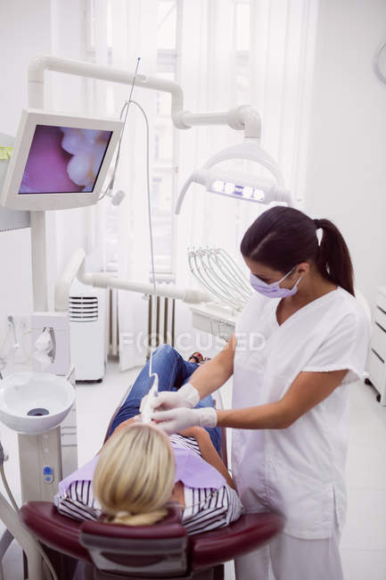 Женщина-дантист осматривает пациента в стоматологической клинике — стоковое фото
