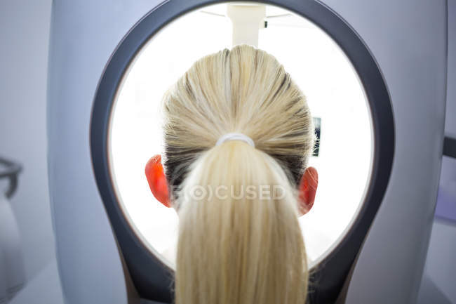 Woman receiving aesthetic laser scan in clinic, rear view — Stock Photo
