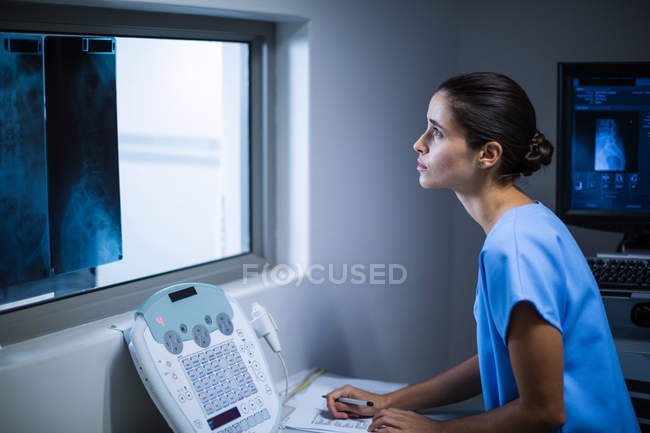 Enfermeira toma notas na sala de raios-X do hospital — Fotografia de Stock