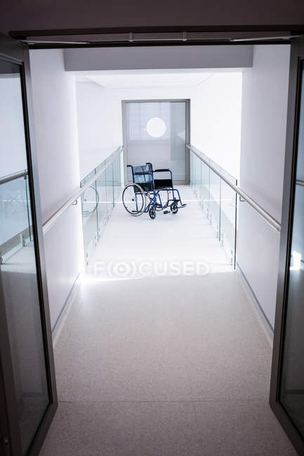 Cadeira de rodas vazia na passagem do hospital — Fotografia de Stock