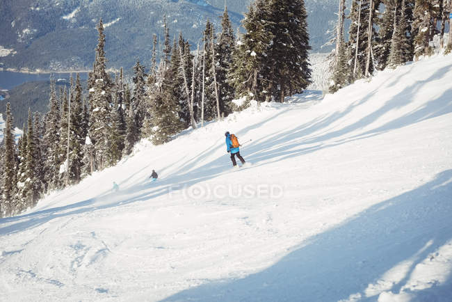Лижники катаються на лижах на засніжених горах — стокове фото