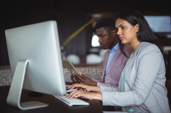 Businessman and a colleague working over computer in office — Stock Photo