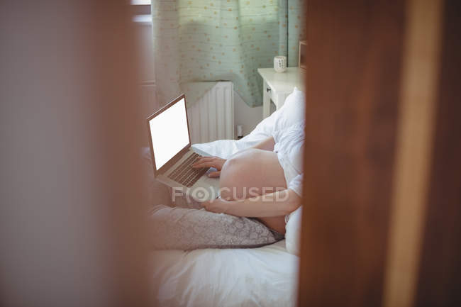 Schwangere entspannt sich auf Bett im Schlafzimmer — Stockfoto