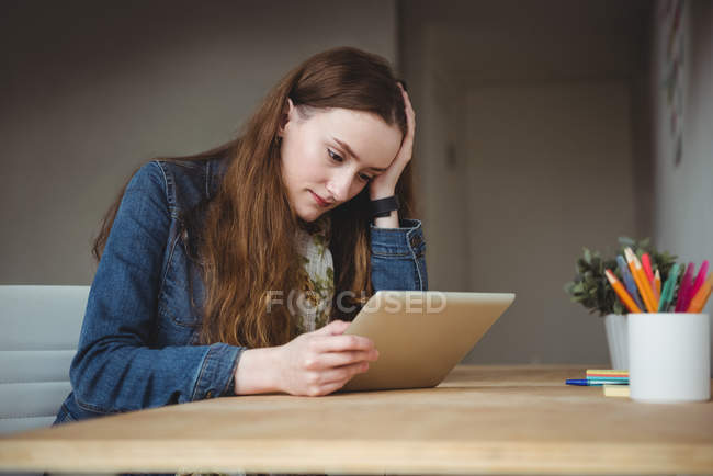 Ejecutiva femenina tensa usando tableta digital en la oficina - foto de stock