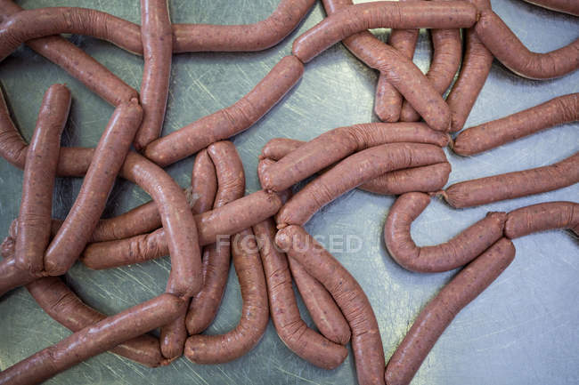Gros plan sur les saucisses crues à l'usine de viande — Photo de stock
