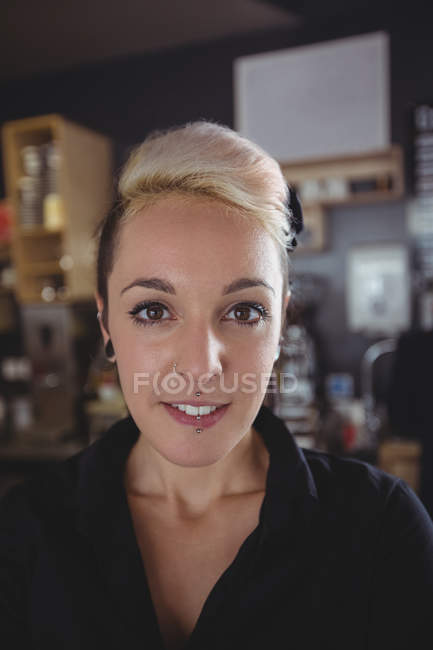 Portrait of smiling waitress in cafe — Stock Photo