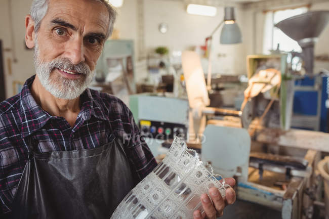 Портрет стеклодува, держащего стеклодувы на стекольном заводе — стоковое фото