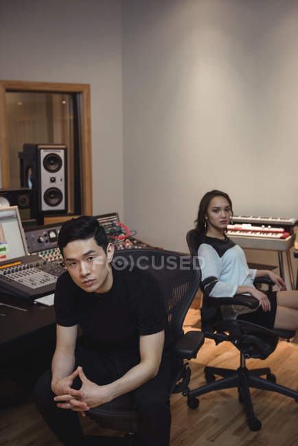 Portrait of audio engineers sitting in recording studio — Stock Photo