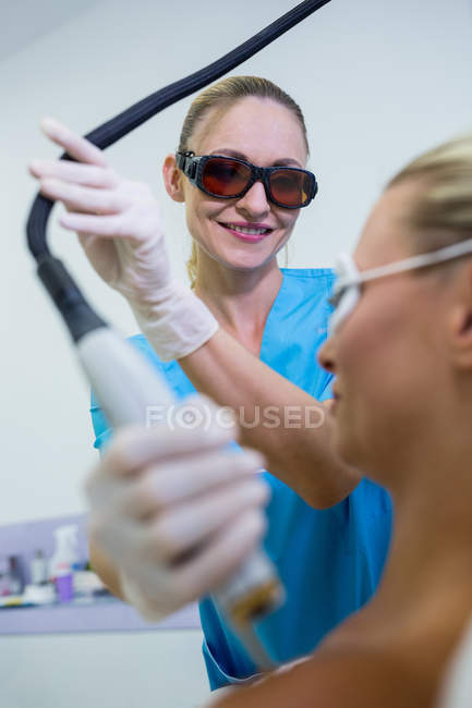 Female patient receiving laser epilation treatment on shoulder at beauty salon — Stock Photo