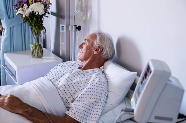 Paciente sênior do sexo masculino relaxando na enfermaria do hospital — Fotografia de Stock