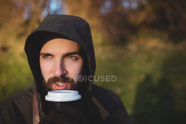 Молодий бородатий чоловік має каву на відкритому повітрі — стокове фото